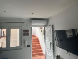 a living room with a tv and a staircase at Casa rooftop jacuzzi and magnificent sea view in Albufeira