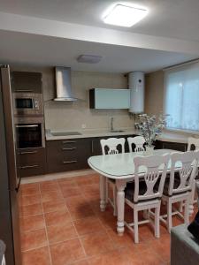 a kitchen with a white table and chairs at La Labranza del Bosque in El Bosque