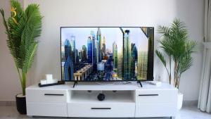 アブダビにあるOasis Luxe 1BR - Near Masdar Park & City Centre Masdarのリビングルームの白いドレッサーの上のテレビ