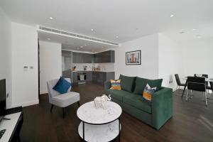 a living room with a green couch and a table at Access Tower Hill in London