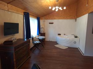 a bathroom with a tub and a sink and a tv at Schwarzwald Escape in Görwihl