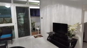 a living room with a flat screen tv on a table at Aguada Hills Residence in Puerto Galera