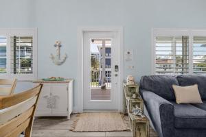 a living room with a blue couch and a door at Welcome to Mermaid Bay Vacation Rental - 261 Delmar home in Fort Myers Beach