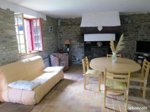 ein Wohnzimmer mit Couch und Tisch in der Unterkunft Gîte de vacances avec wifi in Quistinic