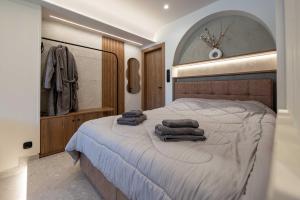 a bedroom with a large bed with towels on it at Frourio Lodge A4 in Larisa