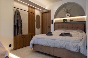 a bedroom with a large bed and a mirror at Frourio Lodge A4 in Larisa