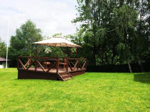 a picnic table with an umbrella in a field at Emire Boutique in Zărneşti