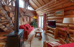 a living room with a fireplace in a log cabin at Chalet mishka in Tendon