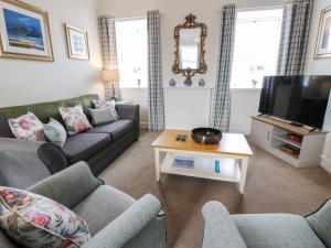 a living room with a couch and a tv at Royal Artillery Cottage - Culzean Castle in Maybole