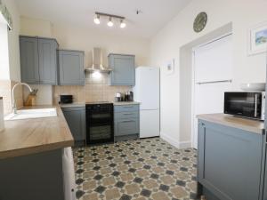 a kitchen with blue cabinets and a counter top at Royal Artillery Cottage - Culzean Castle in Maybole