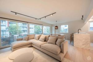 a living room with a couch and a table at Stylish apartment in Knokke - Balcony city view in Knokke-Heist