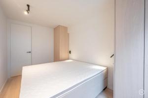 a white bedroom with a white bed in it at Stylish apartment in Knokke - Balcony city view in Knokke-Heist
