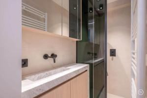 a bathroom with a sink and a shower at Stylish apartment in Knokke - Balcony city view in Knokke-Heist +3 photos