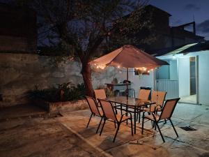 a table with chairs and an umbrella on a patio at Casa Cálida Relajante y Céntrico con Estacionamiento in San Cristóbal de Las Casas