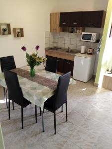 a kitchen with a table with a vase of flowers on it at Apartment Buic in Pula