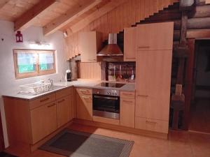 a kitchen with wooden cabinets and a stove top oven at Chalet San Bernardino in San Bernardino