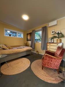 ein Schlafzimmer mit Bett, Stuhl und Schreibtisch in der Unterkunft Kvernhusheia Gjestegård in Rødland