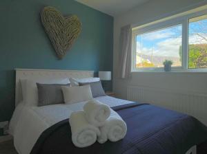 a bedroom with a bed with two towels on it at Fern Cottage in Portinscale