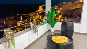 a plate of food on a balcony with a view of a city at Casas Colgadas Alcalá del Júcar in Alcalá del Júcar