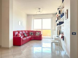 a red couch in a living room with a window at Homeby, Casa Cartesio in Milan +45 photos