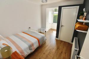 a bedroom with a bed and a wooden floor at Viewcliff in Scalloway
