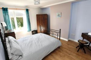 a bedroom with a bed and a desk and a window at Viewcliff in Scalloway +2 photos