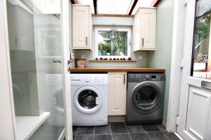 a small laundry room with a washer and dryer at Viewcliff in Scalloway