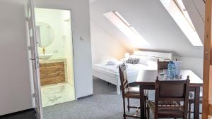 a bedroom with a bed and a table and a bathroom at Rezydencja Dwór Górny in Nowa Ruda +74 photos