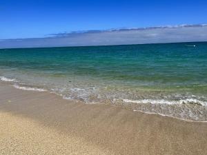 a beach with the ocean and the sand and water at ビーチサイドペンションみーばる in Nanjo