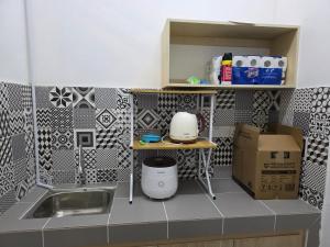 a small kitchen with a sink and a counter top at Aqimi Homestay in Seri Iskandar