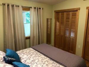 a bedroom with a bed and a window at The Bungalow -- Minutes from the Airport - on the Way to the Glacier in Juneau