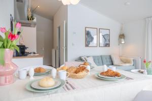 a table with plates of bread and pastries on it at Buitenlede 7 - Suite M in Dwingeloo