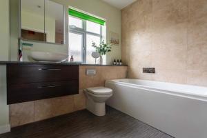 a bathroom with a tub and a toilet and a sink at Bath City Haven with Free Parking in Bath