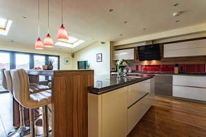 a kitchen with a counter and a bar with chairs at Bath City Haven with Free Parking in Bath