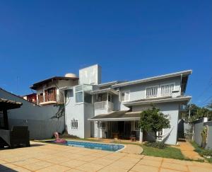 a large white house with a pool in front of it at Casa para alugar 3 suítes e um Quarto in Campinas