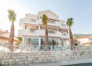 a building with palm trees in front of it at Hotel Bela Roza in Bijela