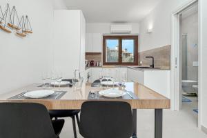 Ginepro Apartment - by And service في Casa Tamponi: مطبخ مع طاولة طعام عليها أكواب