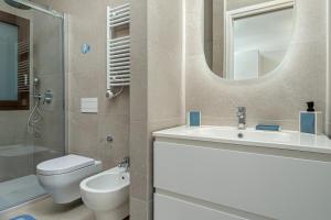 Ginepro Apartment - by And service في Casa Tamponi: حمام مع حوض ومرحاض ومرآة +13 صورة