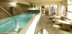 een badkamer met een zwembad, twee wastafels en toiletten bij Suite Hotel Santa Chiara in Lecce