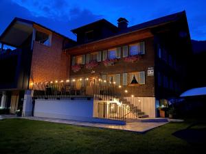 a house with lights on the side of it at Chalet & Almhostel Alpenperle - Selbstversorger Unterkunft in Tannheim