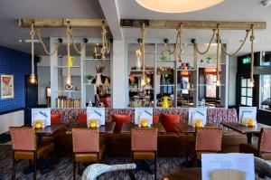 a restaurant with tables and chairs and a bar at Downs Hotel in Stanmer
