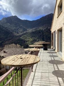 a row of wooden benches on a balcony with mountains at Auberge chez François in Ortale