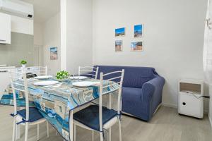 サン・テオドーロにあるI giardini di Cala D'ambraのテーブルと青いソファのあるリビングルーム +8枚の写真