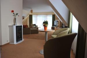 a living room with a couch and a table and chairs at Hotel Am Alten Strom in Warnemünde