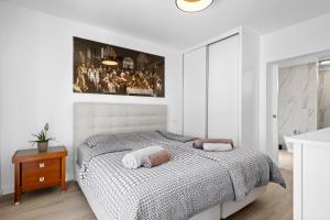 ein Schlafzimmer mit einem Bett und einem Gemälde an der Wand in der Unterkunft Casa do Cabeco in Vila Baleira