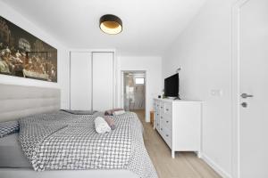 ein weißes Schlafzimmer mit einem Bett und einem Fernseher in der Unterkunft Casa do Cabeco in Vila Baleira