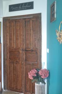 a wooden door in a room with flowers in a vase at MAISON BERTINEAU proche Saint-Emilion in Néac
