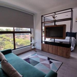 un soggiorno con divano verde e TV di Apartaestudio Moderno a Cali
