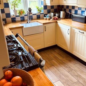 a kitchen with a sink and a stove top oven at Charming Dorset Seaside Escape in Burton +28 photos