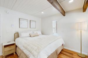 een witte slaapkamer met een groot bed en een raam bij The Sunny Saddle in Incline Village